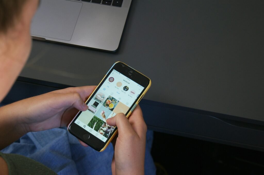 Person hält ein iPhone in der Hand und nutzt das Smartphone, Fokus auf das Gerät und die Hand des Nutzers