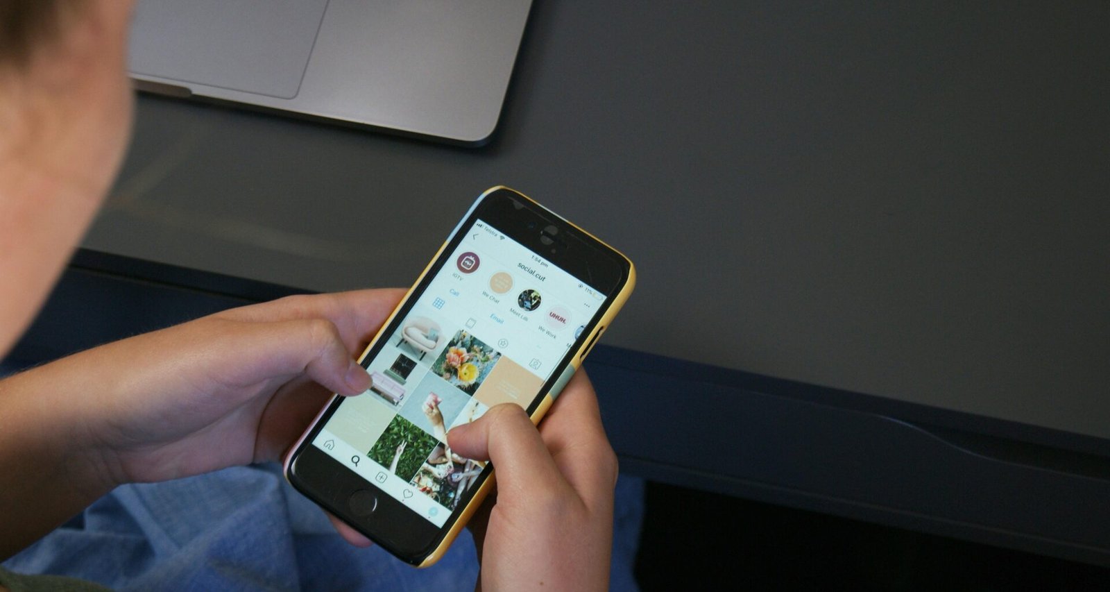 Person hält ein iPhone in der Hand und nutzt das Smartphone, Fokus auf das Gerät und die Hand des Nutzers