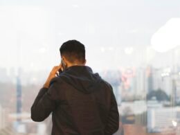 Nahaufnahme einer Person, die ein Smartphone mit beiden Händen hält, Fokus auf dem Gerät, Hintergrund unscharf