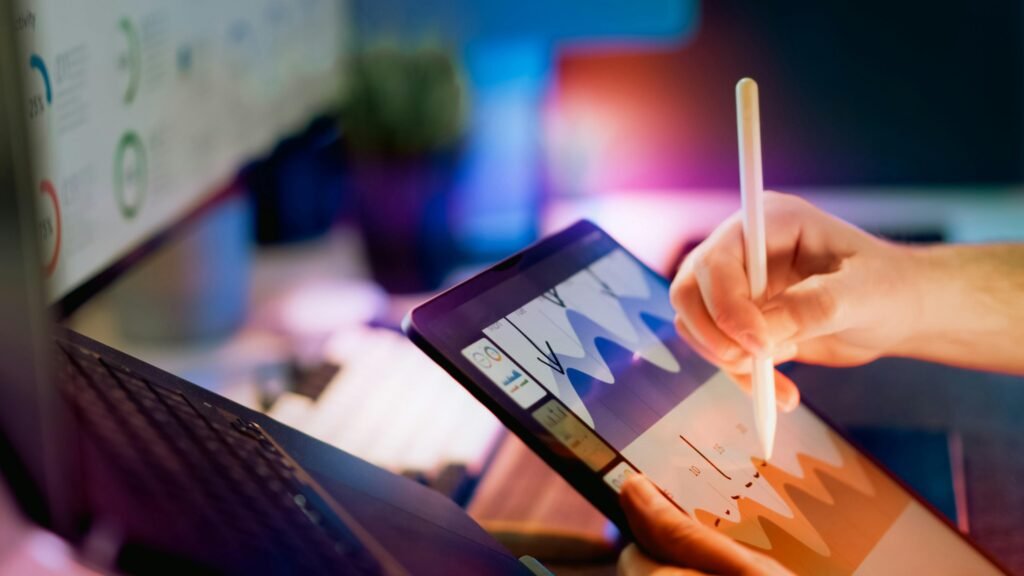 Person nutzt einen Stylus auf einem Tablet, um Diagramme und Datencharts zu analysieren; modernes Arbeiten mit digitalen Tools.