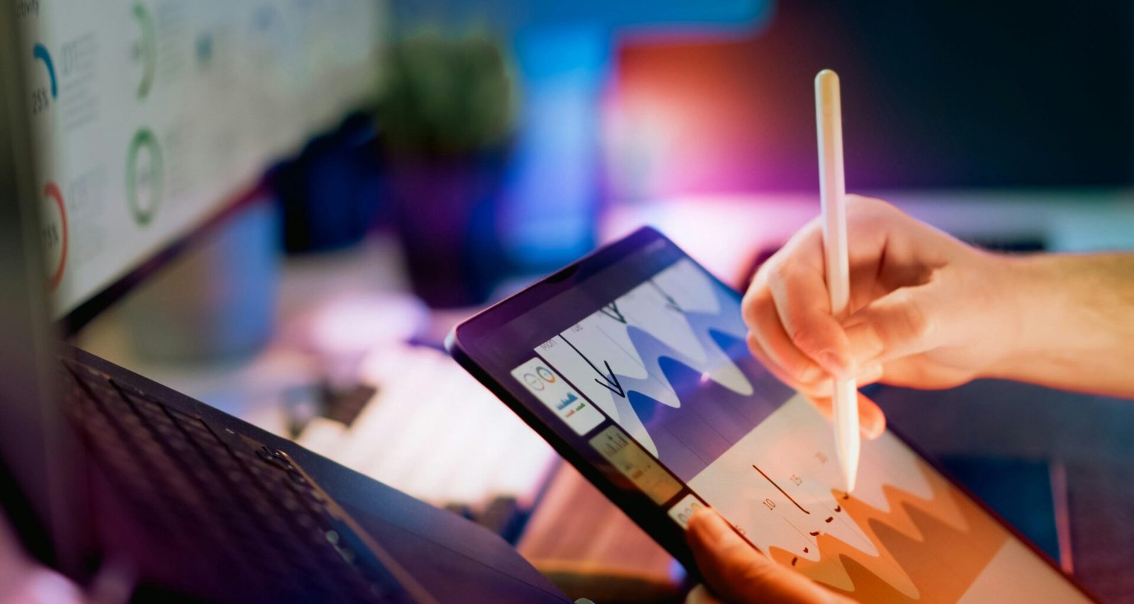 Person bedient Tablet mit Stylus und analysiert Diagramme auf dem Bildschirm, Fokus auf digitale Datenverarbeitung.