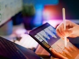Person bedient Tablet mit Stylus und analysiert Diagramme auf dem Bildschirm, Fokus auf digitale Datenverarbeitung.