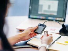 Person verbindet eine externe Festplatte mit einem Kartenleser, um Daten zwischen Speichergeräten auszutauschen.