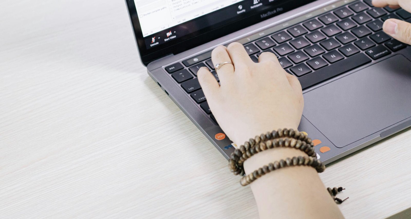 Eine Person arbeitet an einem schwarzen und silbernen Laptop an einem Tisch, moderne Technologie im Geschäftsalltag
