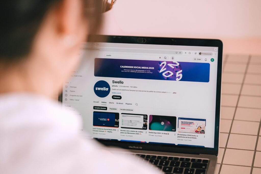 Person betrachtet auf dem Laptop einen YouTube-Kanal und informiert sich über Video-Marketing am Schreibtisch