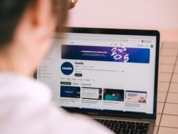 Person streamt einen YouTube-Kanal auf einem aufgeklappten Laptop an einem Arbeitstisch