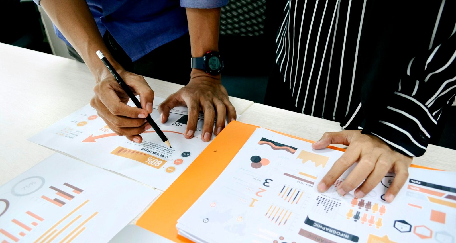 Person mit blauem Hemd verfasst handschriftliche Notizen auf weißem Papier an einem Schreibtisch