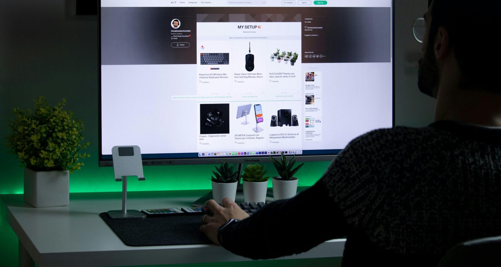 Eine Person in schwarzem Pullover arbeitet konzentriert an einem Computer an einem modernen Arbeitsplatz.