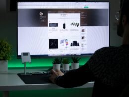 Person mit schwarzem Pullover arbeitet konzentriert an einem Computerarbeitsplatz im Büro oder Homeoffice