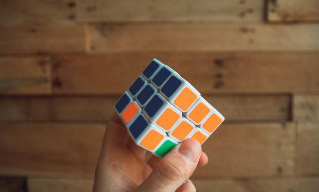 Eine Person hält einen klassischen 3x3 Rubik's Cube in den Händen, Fokus auf das bunte Puzzle und die Handhaltung.