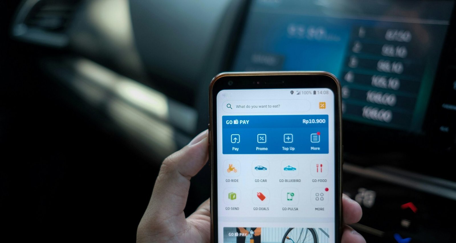 Eine Person hält ein Android-Smartphone in der Hand, Fokus auf das Mobilgerät, neutraler Hintergrund.