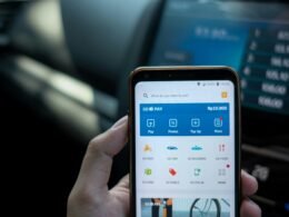 Eine Person hält ein Android-Smartphone in der Hand, Fokus auf das Mobilgerät, neutraler Hintergrund.