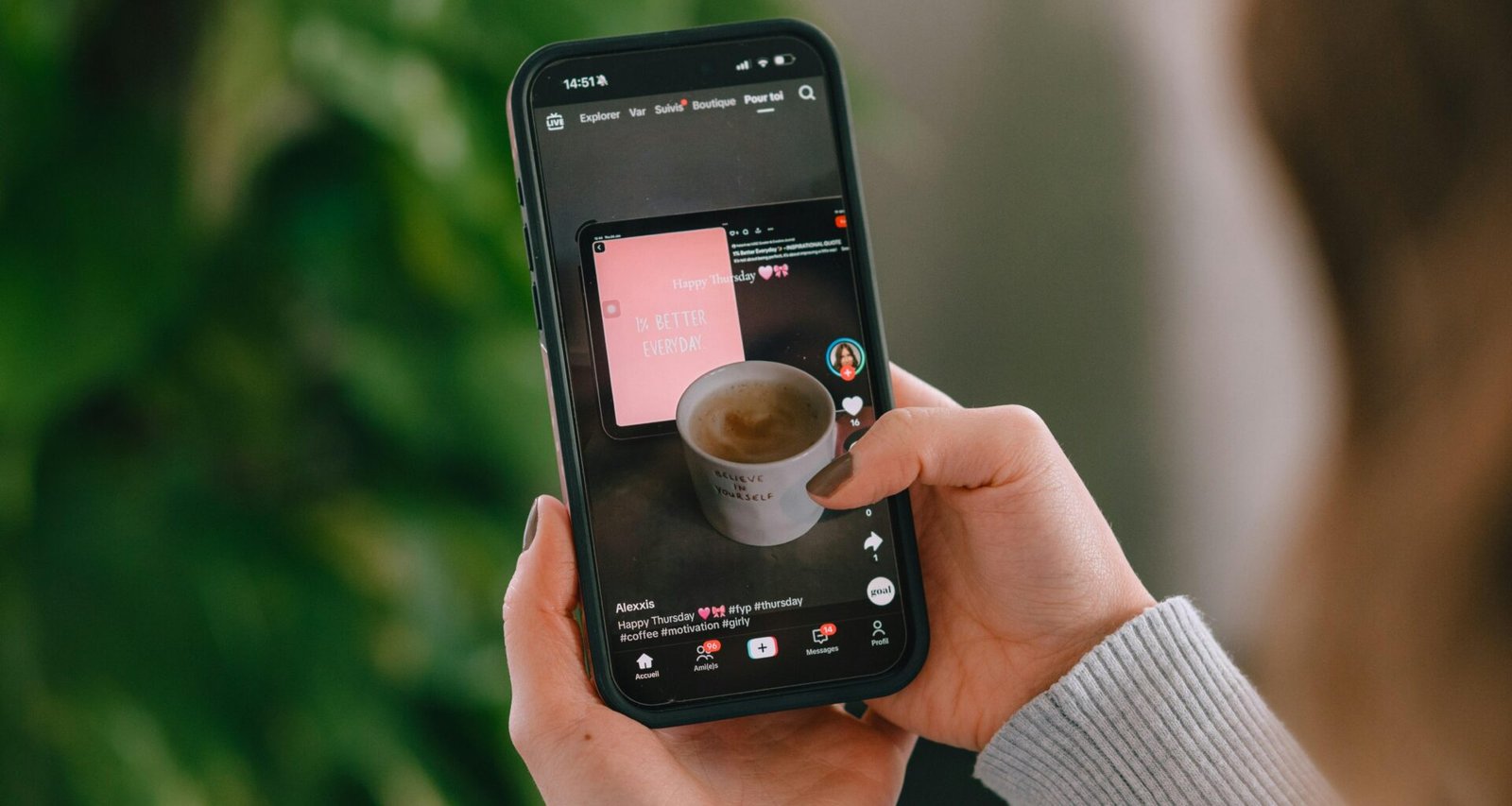 Person hält ein Smartphone, auf dem eine Kaffeetasse auf dem Bildschirm angezeigt wird, Nahaufnahme der Hand mit Handy