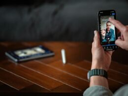 Eine Person hält ein Smartphone in der Hand und führt einen Videoanruf, der das Display deutlich im Mittelpunkt zeigt.