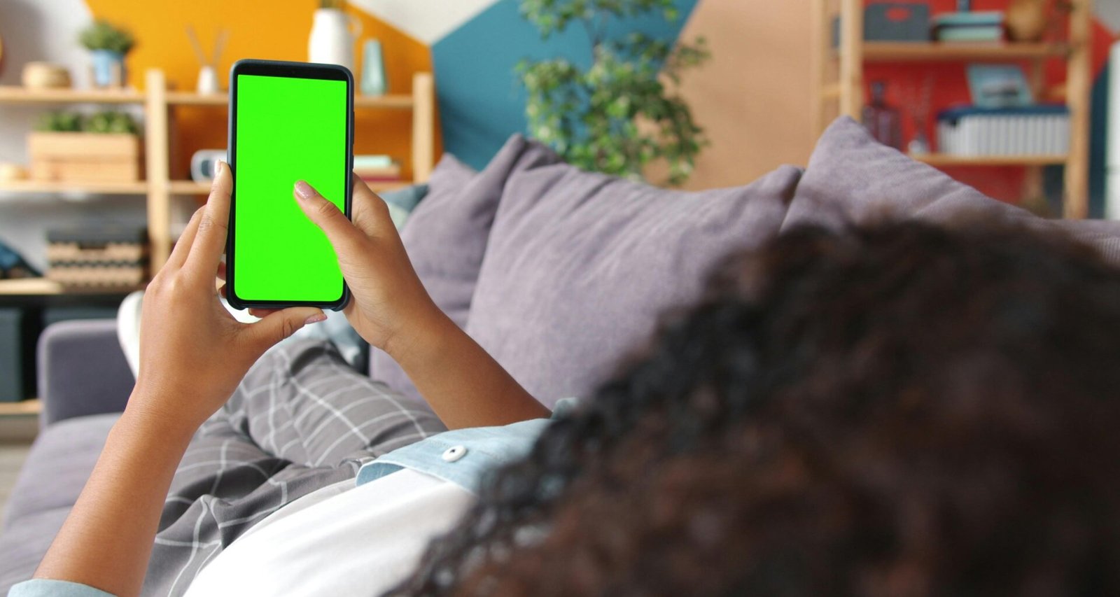 Person hält ein Smartphone mit grünem Screen in der Hand – ideal für Technologie- und Marketingthemen.