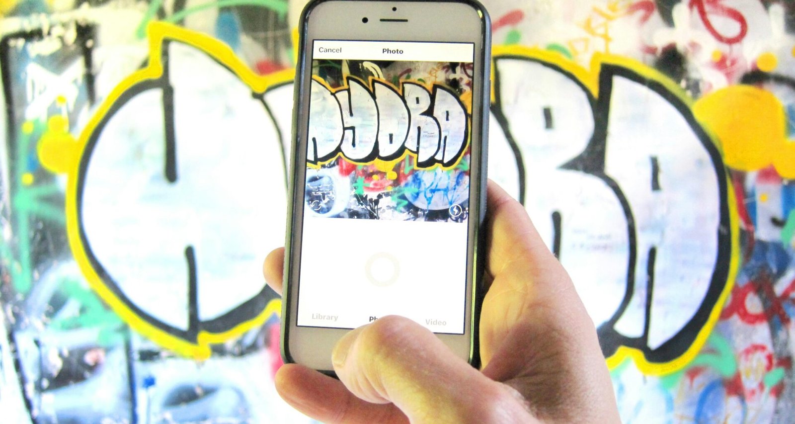 Eine Person hält ein goldfarbenes iPhone 6 in der Hand, das Smartphone wird von unten fotografiert