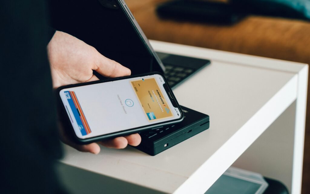 Eine Person hält ein schwarzes Android-Smartphone in der Hand, das für modernes mobiles Arbeiten steht.