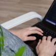 Eine Person nutzt einen schwarzen Asus Laptop auf einem Tisch, ideal für flexibles und effizientes Arbeiten