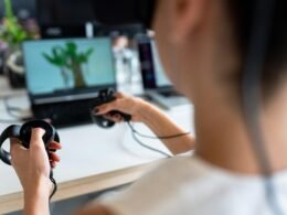 Nahaufnahme einer Person mit einem schwarzen Gamecontroller in der Hand, die einen modernen Gaming-Trend veranschaulicht.