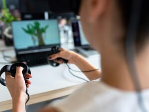 Nahaufnahme einer Person mit einem schwarzen Gamecontroller in der Hand, die einen modernen Gaming-Trend veranschaulicht.