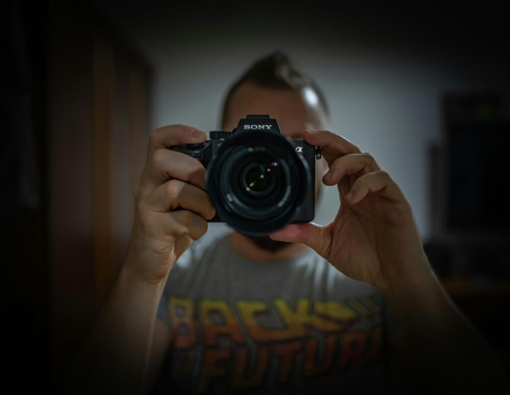 Eine Person hält eine schwarze Nikon DSLR Kamera in den Händen – moderner Ansatz für Technik- und Fotografieartikel