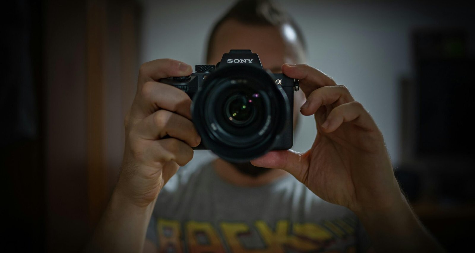 Eine Person hält eine schwarze Nikon DSLR Kamera in den Händen – moderner Ansatz für Technik- und Fotografieartikel