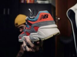 Person hält einen weißen, roten und blauen Nike Air Max Sneaker in der Hand, Fokus auf das markante Design des Schuhs