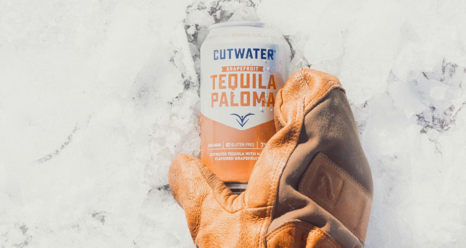 Person mit braunen Lederhandschuhen hält eine weiß und orange beschriftete Dose, Nahaufnahme als Beitragsbild zu Technologiethemen