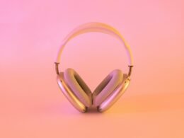 Kabellose Kopfhörer in Pink und Weiß liegen auf einer neutralen Oberfläche, modernes Design mit bequemen Ohrmuscheln.