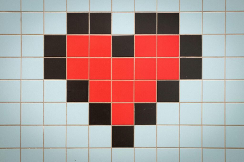 Ein pixeliertes, rotes Herz auf einem hellblau gekachelten Hintergrund, aufgenommen von Stephen Harlan