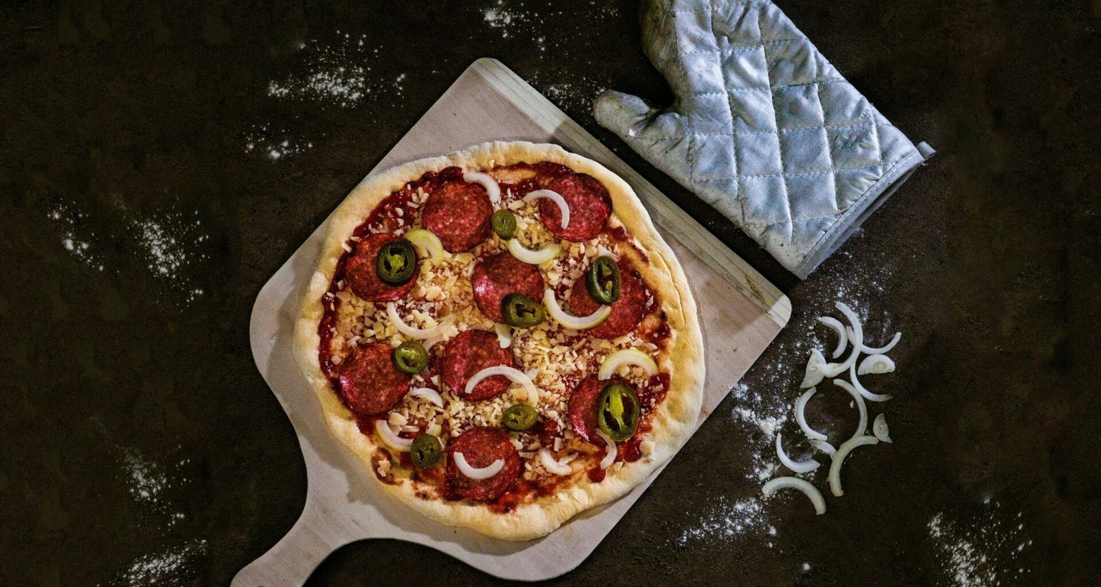 Frisch gebackene Pizza, serviert auf einem braunen Holztablett, von oben fotografiert auf hellem Untergrund