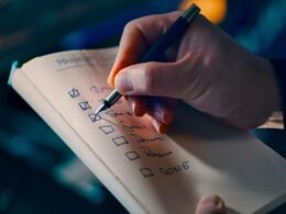 Hand markiert erledigte Aufgaben auf einer To-do-Liste, Fokus auf produktives Aufgabenmanagement im Alltag