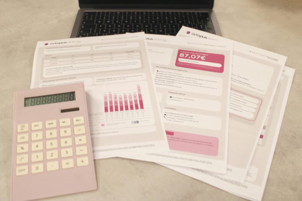 Rechnungen, ein Taschenrechner und ein Laptop auf einem Schreibtisch – effiziente Bearbeitung finanzieller Aufgaben.