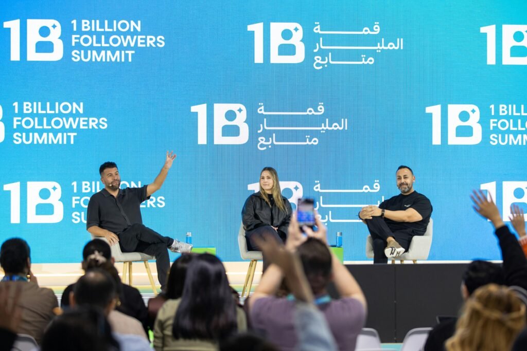 Mehrere Speaker präsentieren auf einer Bühne während des 1 Billion Followers Summit vor großem Publikum.