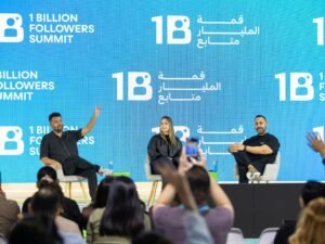 Mehrere Speaker präsentieren auf einer Bühne während des 1 Billion Followers Summit vor großem Publikum.