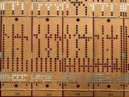Mehrere Reihen alter gestanzter Lochkarten zur Datenspeicherung, nebeneinander angeordnet, historische Informationstechnologie