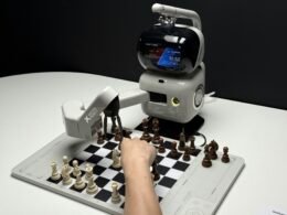 Roboterarm, der beim Schachspielen mit einer menschlichen Hand konkurriert, symbolisiert KI-Entwicklung und Technologie