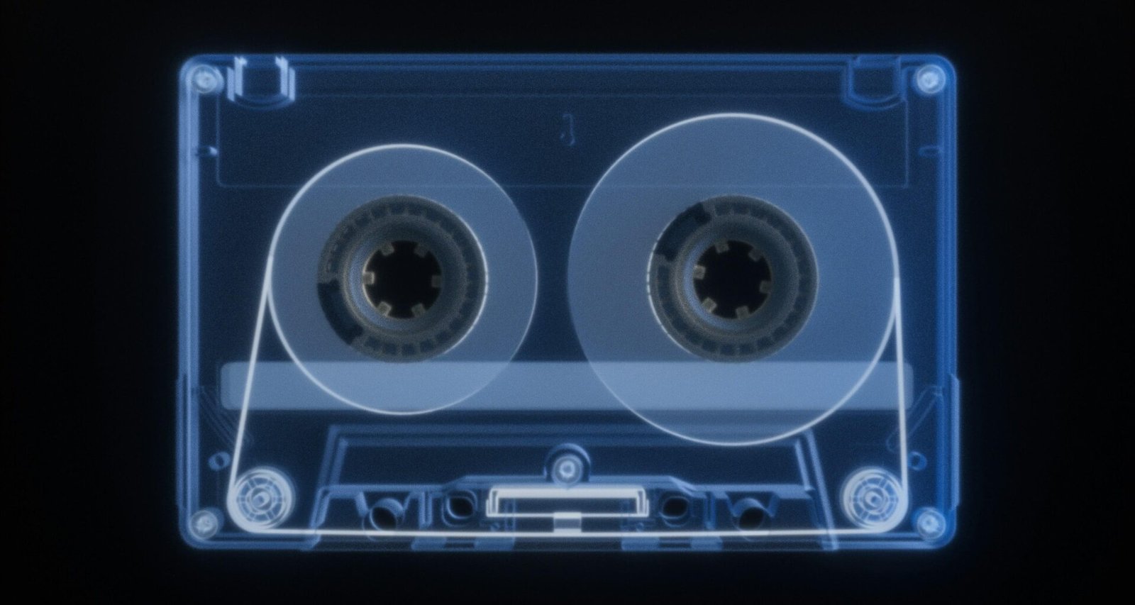 Röntgenaufnahme einer Vintage Kassette auf schwarzem Hintergrund mit sichtbaren inneren Mechanikteilen.