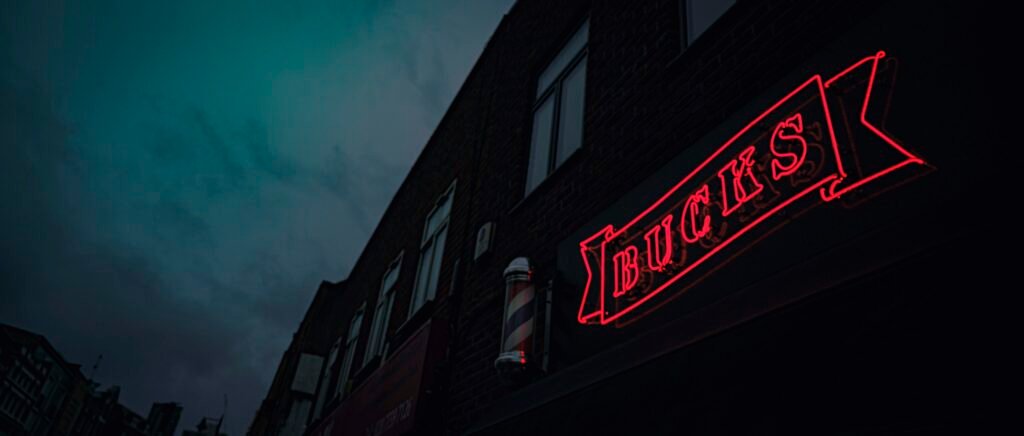 Rot-weißes Coca Cola Neon-Leuchtschild in dunkler Umgebung, Symbol für Markenpräsenz und Retro-Stil.