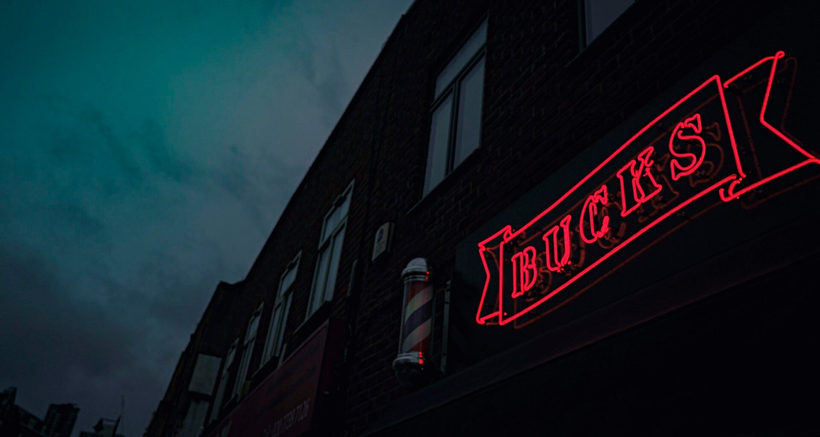 Rot-weißes Coca Cola Neon-Leuchtschild in dunkler Umgebung, Symbol für Markenpräsenz und Retro-Stil.
