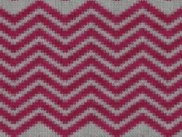 Nahaufnahme eines roten und weißen Chevron-Textilstücks mit klar sichtbarem Zackenmuster und strukturierter Oberfläche