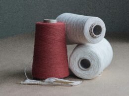 Roter Faden liegt ausgebreitet auf einem braunen Holztisch, Detailaufnahme, ideal für Themen rund um Planung und Strategie