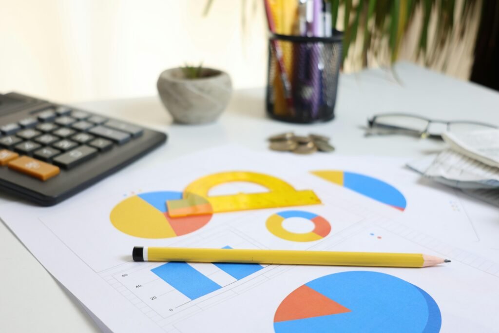 Schreibtisch mit Taschenrechner, ausgedruckten Charts und Bleistift, bereit für die Analyse von Geschäftsdaten