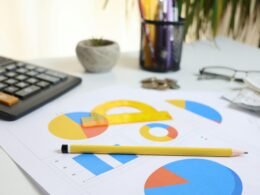 Schreibtisch mit Taschenrechner, ausgedruckten Charts und Bleistift, bereit für die Analyse von Geschäftsdaten