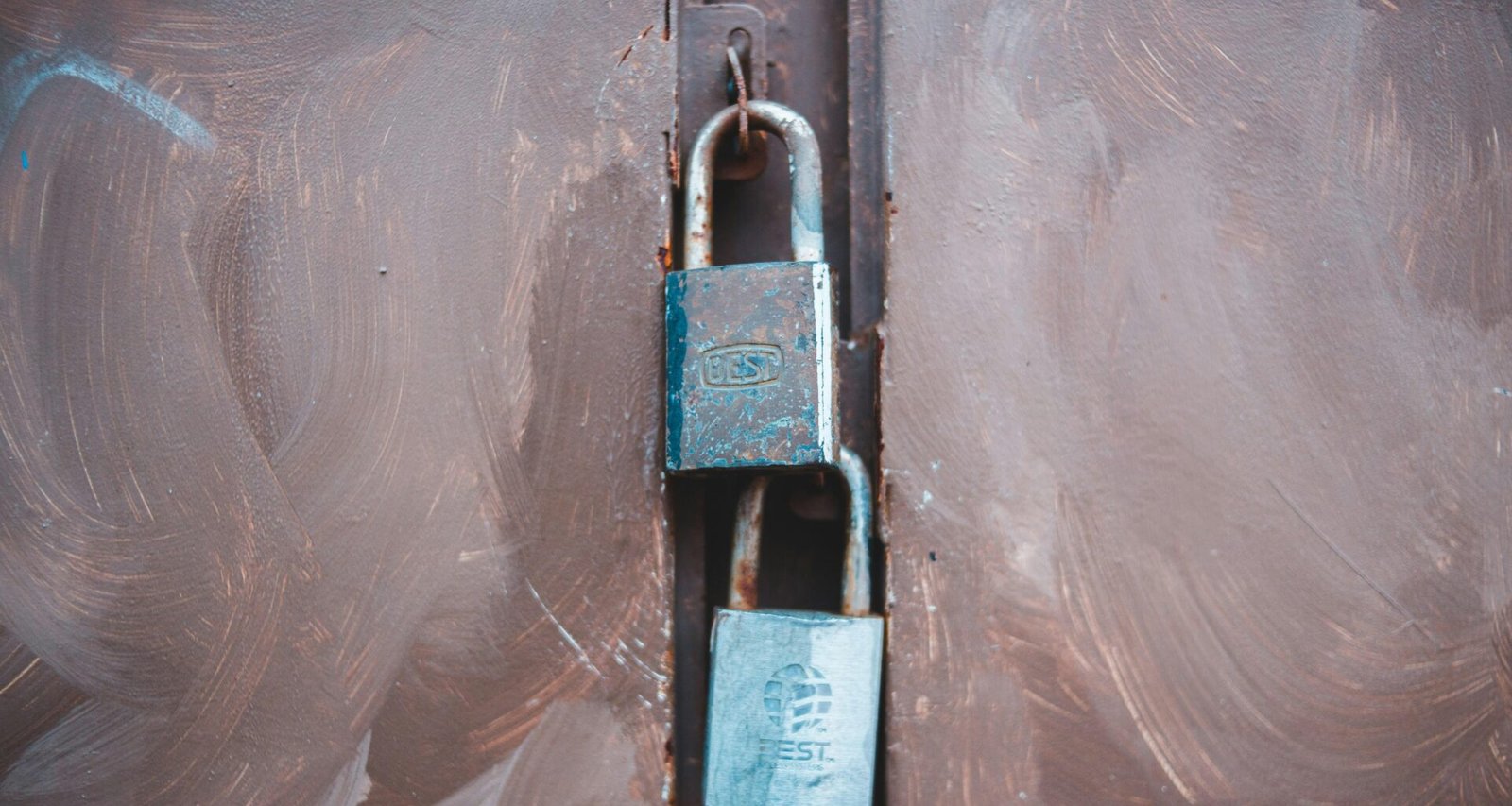 Schwarzes und silbernes Vorhängeschloss liegt auf weißem Kunststoff, Detailaufnahme zur Darstellung von Sicherheit