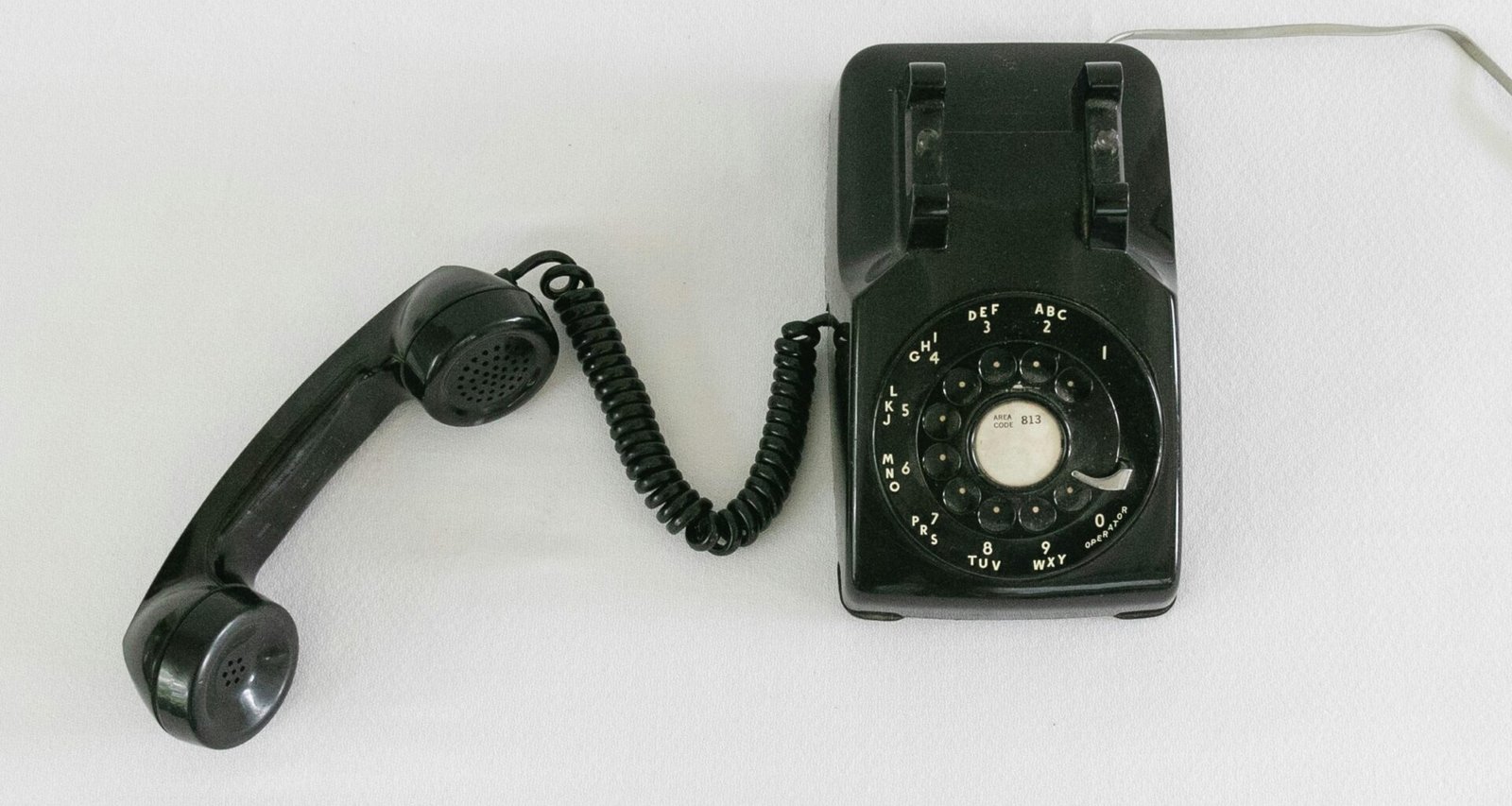 Nahaufnahme eines klassischen schwarzen und silbernen Wählscheibentelefons, ideal für Artikel über Technikgeschichte oder Kommunikation.