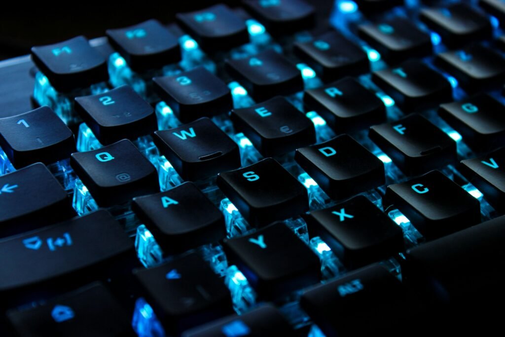 Schwarz-weiße Computertastatur auf einem Schreibtisch, fotografiert aus der Nähe mit Fokus auf die Tasten.