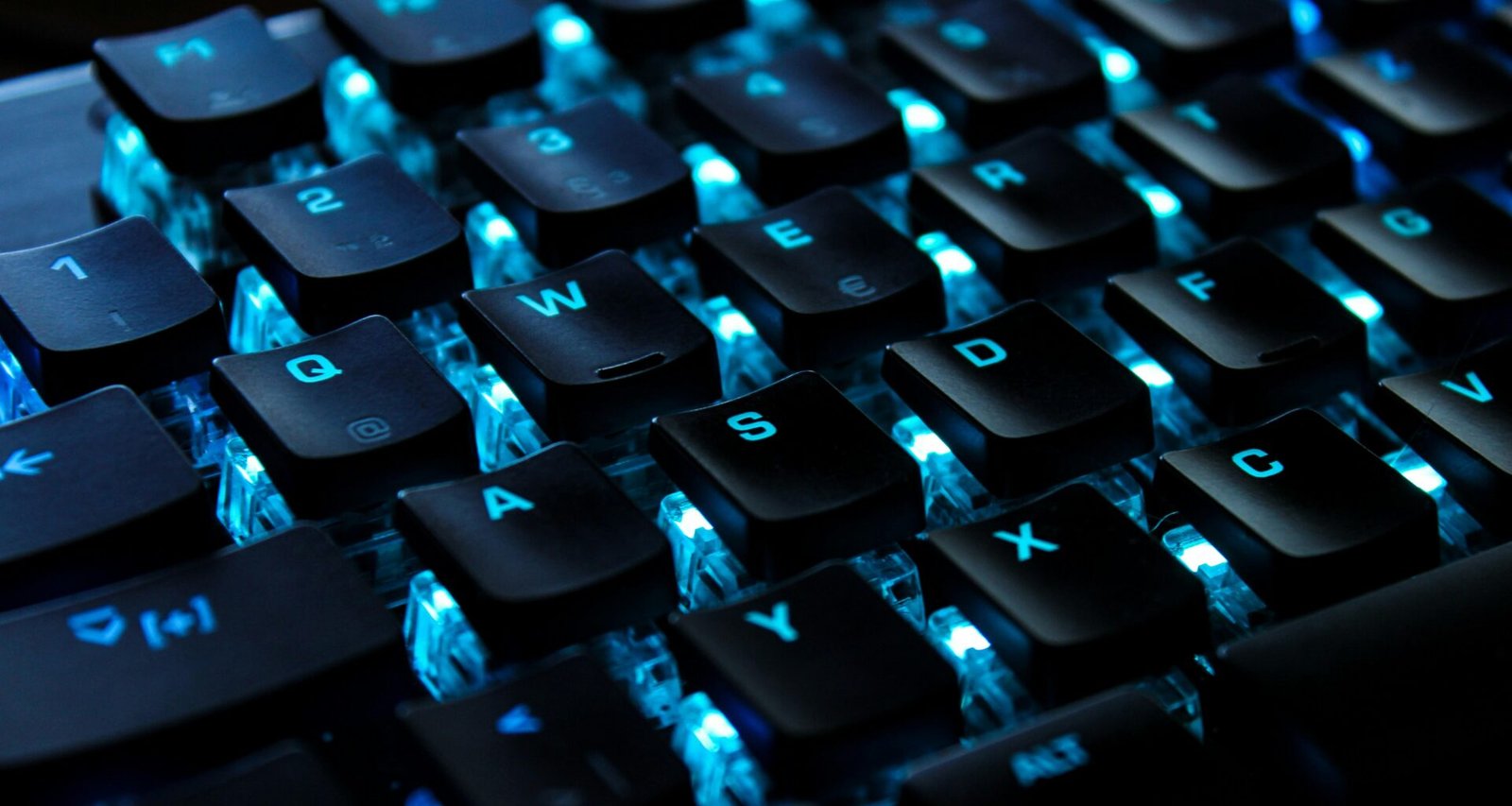 Schwarz-weiße Computertastatur auf einem Schreibtisch, fotografiert aus der Nähe mit Fokus auf die Tasten.