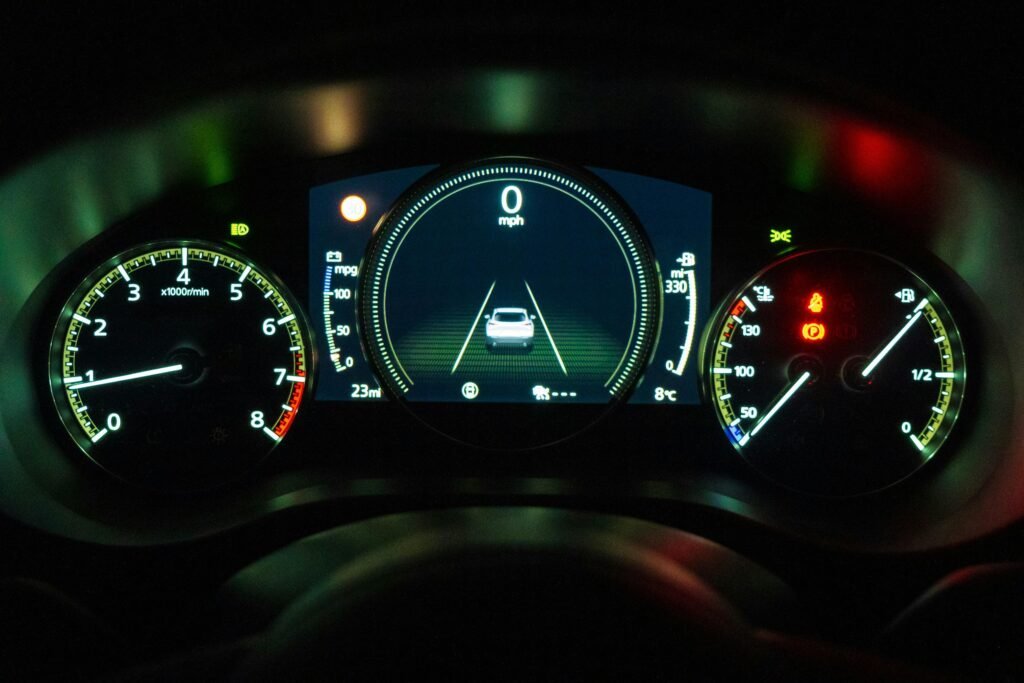 Schwarz-weiß Fotografie eines digitalen Auto-Armaturenbretts mit Tacho und Drehzahlanzeige im Fokus