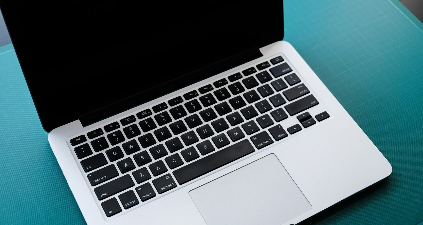 Schwarz-weiß Aufnahme eines geöffneten Laptops auf einem Tisch, ideal für Themen rund um Technik und Online-Arbeit